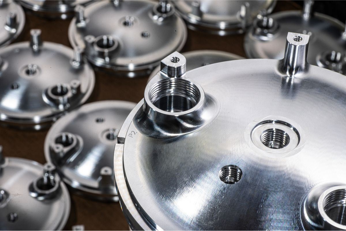 Batch of machined metal parts with threaded ports