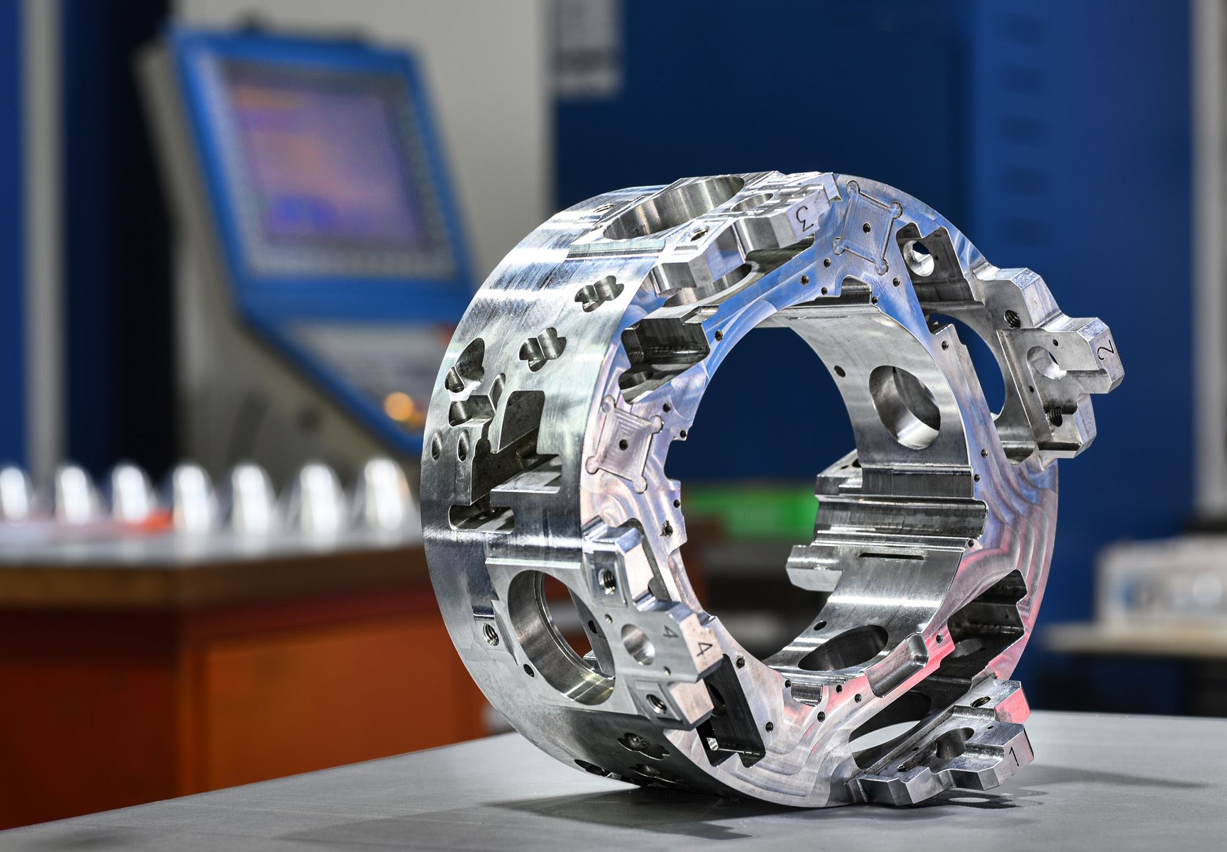 Large machined ring housing with internal pockets and bores
