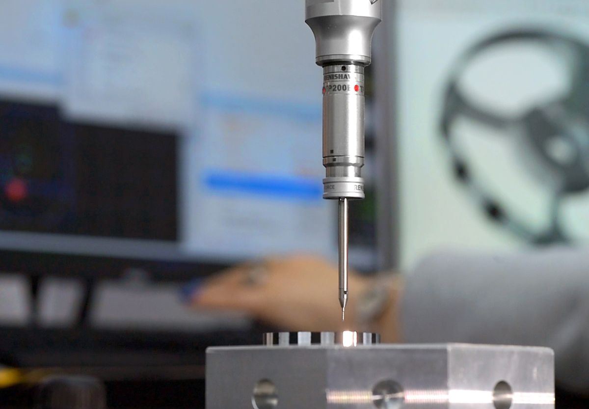CMM probe inspecting machined aluminum part dimensions